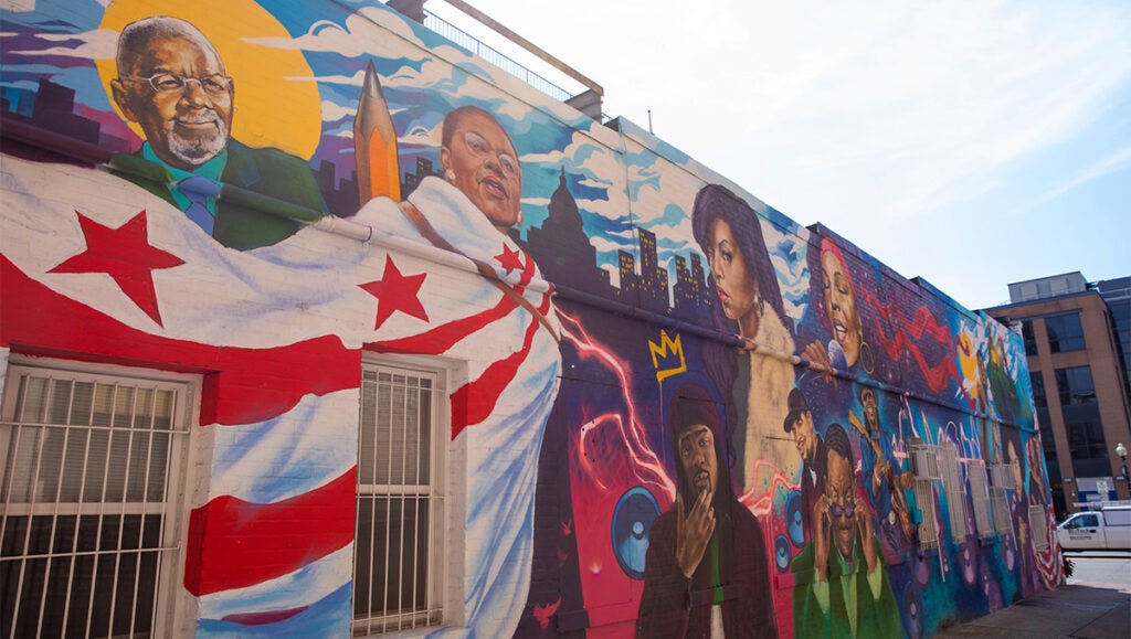A colorful mural on a building wall in downtown DC depicts African Americans from the city's history